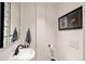 This stylish powder room features an updated sink, fixtures, and unique artwork at 1991 E Alameda Ave # 14, Denver, CO 80209