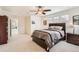 Large bedroom with neutral walls, ceiling fan, plush carpet, and a dark wood bed frame at 3597 Xanthia St, Denver, CO 80238