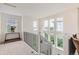 Bright upstairs hallway featuring large windows, plush carpet, and modern railings at 3597 Xanthia St, Denver, CO 80238