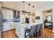 Stunning kitchen featuring an island with bar seating, modern pendant lighting and stainless steel appliances at 3597 Xanthia St, Denver, CO 80238