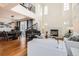 Open-concept living room with soaring ceilings, fireplace, grand piano, and dining area at 3597 Xanthia St, Denver, CO 80238