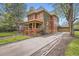 Spacious red brick home with a long driveway leading to a detached garage and a wraparound porch at 835 Niagara St, Denver, CO 80220