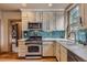 Renovated kitchen with stainless steel appliances, granite countertops, and custom tile backsplash at 835 Niagara St, Denver, CO 80220
