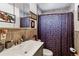 Cozy bathroom with a single sink vanity, tiled walls, and a patterned shower curtain at 4942 W 9Th Ave, Denver, CO 80204