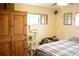 Bedroom with wood armoire, a cat tree, and a bed with a gray plaid comforter at 4942 W 9Th Ave, Denver, CO 80204