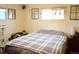 Bedroom featuring a bed with plaid blanket and windows decorated with decorative flower boxes at 4942 W 9Th Ave, Denver, CO 80204