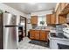 Functional kitchen with wood cabinets and stainless-steel refrigerator at 4942 W 9Th Ave, Denver, CO 80204