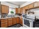 This kitchen has wood cabinets, a stainless-steel sink and standard appliances at 4942 W 9Th Ave, Denver, CO 80204