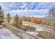 View of backyard from deck with snow and ground cover with a walking path, bushes, and trees at 1339 Bent Grass Cir, Castle Rock, CO 80109