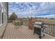 Large deck with outdoor table, grill, brick accents, and view of surrounding neighborhood and golf course at 1339 Bent Grass Cir, Castle Rock, CO 80109