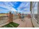 Large wooden deck with brick features, outdoor furniture, and views of the sky and distant landscape at 1339 Bent Grass Cir, Castle Rock, CO 80109