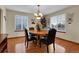 Cozy dining room features hardwood floors, a round wood table, four chairs and a chandelier at 1339 Bent Grass Cir, Castle Rock, CO 80109