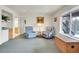 Bright living room featuring two blue armchairs, a small wet bar, and a view to the outside at 1339 Bent Grass Cir, Castle Rock, CO 80109