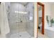 Glass enclosed shower with tiled walls and decorative accents and an open view into the toilet and tub area at 1339 Bent Grass Cir, Castle Rock, CO 80109