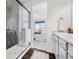 Bathroom showcases the shower stall with geometric tile, vanity, and access to the bedroom at 18129 E 99 Pl, Commerce City, CO 80022
