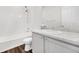 Bright bathroom featuring a tub with shower, white tile surround, marbled vanity top and wood-look flooring at 18129 E 99 Pl, Commerce City, CO 80022