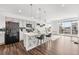 Modern kitchen with stainless steel appliances, a large center island, and hardwood floors at 18129 E 99 Pl, Commerce City, CO 80022