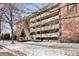 Apartment complex exterior featuring brick walls, multiple balconies and snow-covered sidewalks at 1243 Gaylord St # 302, Denver, CO 80206