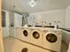 Bright laundry room with several washing machines, dryers, and service postings at 1243 Gaylord St # 302, Denver, CO 80206