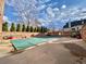 Outdoor pool area with brick walls, trimmed shrubs, and a pool cover at 1243 Gaylord St # 302, Denver, CO 80206
