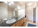 Well-lit bathroom featuring double sinks, spacious countertops, and tiled flooring at 3100 Blue Sky Cir # 205, Erie, CO 80516