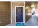 Unit 205's front door with wreath and 'hello' bike mat, in a hallway with wood panels at 3100 Blue Sky Cir # 205, Erie, CO 80516
