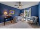 Charming bedroom with blue walls, complemented by a ceiling fan and a cozy sitting area at 3860 Mallard Dr, Highlands Ranch, CO 80126