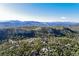 An aerial view showcasing mountains, homes, and a forest at 6857 Timbers Drive, Evergreen, CO 80439