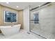 Well lit bathroom with a modern soaking tub, glass shower, and tiled walls at 6857 Timbers Drive, Evergreen, CO 80439