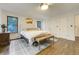 Bright bedroom with hardwood floors, three windows and stylish lighting fixture at 6857 Timbers Drive, Evergreen, CO 80439