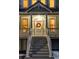 Charming front door with decorative wreath, sidelights, and steps leading to the porch at 6857 Timbers Drive, Evergreen, CO 80439