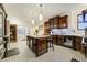 Bright kitchen with dark wood cabinets, kitchen island, and black and white patterned floor tiles at 6857 Timbers Drive, Evergreen, CO 80439