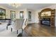 Bright living room featuring hardwood floors, large windows, and an ornate fireplace mantel at 6857 Timbers Drive, Evergreen, CO 80439