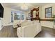Bright living room featuring hardwood floors, white sofas, and a charming bay window seating area at 6857 Timbers Drive, Evergreen, CO 80439