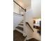 Traditional staircase leads to kitchen with dark cabinets and tiled floor at 6857 Timbers Drive, Evergreen, CO 80439