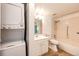 This well-lit bathroom features a shower-tub combo and includes a convenient, in-unit washer and dryer setup at 13890 E Marina Dr # 107, Aurora, CO 80014