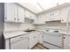 White kitchen with updated appliances and wood-look floors at 13890 E Marina Dr # 107, Aurora, CO 80014