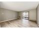 Unfurnished living room showing neutral walls, hardwood floors, and sliding glass door to an outdoor space at 13890 E Marina Dr # 107, Aurora, CO 80014