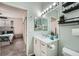 Bathroom with vanity, mirror, and shelving, alongside a view into an adjacent bedroom at 3262 E 103Rd Dr # 1810, Thornton, CO 80229