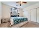 Well-lit bedroom with a comfortable bed, ceiling fan, and convenient closet storage at 3262 E 103Rd Dr # 1810, Thornton, CO 80229
