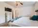 Bedroom featuring a dresser with TV and large bed in front of bathroom door at 3262 E 103Rd Dr # 1810, Thornton, CO 80229