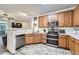 Modern kitchen featuring stainless steel appliances, wooden cabinets, and open layout at 3262 E 103Rd Dr # 1810, Thornton, CO 80229