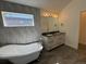Elegant bathroom with a freestanding tub, double sink vanity, and stylish gray tile accent wall at 3440 W 33Rd Ave, Denver, CO 80211