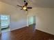 Bright living room featuring wood floors, ceiling fan, and an open doorway to the ensuite bathroom at 3440 W 33Rd Ave, Denver, CO 80211