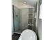 Modern glass-enclosed shower with mosaic tile accents, a rainfall showerhead, and built-in shelving at 3440 W 33Rd Ave, Denver, CO 80211