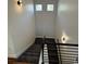 Carpeted staircase with modern metal railing and wall sconces, offering safe access to the second level at 3440 W 33Rd Ave, Denver, CO 80211