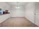 Bright dining area with neutral carpet, chandelier, pass through, and adjacent doorway at 12108 Melody Dr # 103, Denver, CO 80234