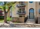 Front elevation of an apartment building with stair access, blue door, and tree lined frontage at 12108 Melody Dr # 103, Denver, CO 80234