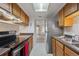 Galley kitchen featuring wooden cabinets, modern stainless steel appliances, and a skylight for natural light at 12108 Melody Dr # 103, Denver, CO 80234