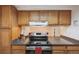 Well-lit kitchen with stainless steel appliances, breakfast bar, and wood cabinets at 12108 Melody Dr # 103, Denver, CO 80234